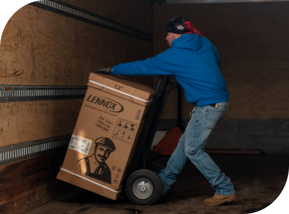 Worker unloading equipment from truck with dolly