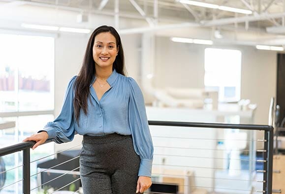 woman in blue blouse with hand on railing